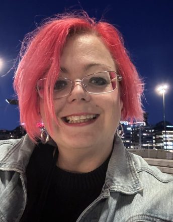 Karin En bild tagen på kvällen, med blå himmel i bakgrunden och kvinna med rosa hår.