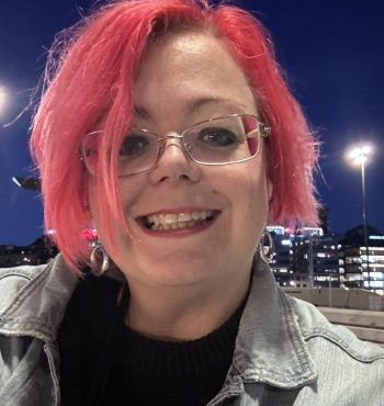 En bild tagen på kvällen, med blå himmel i bakgrunden och kvinna med rosa hår.